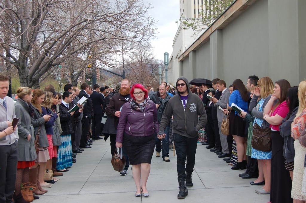 Atheist marchers walk between those singing Church hymns in the free-speech zones along North Temple Street.