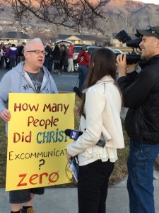 Representatives of Channel 2 news interview a participant in John Dehlin's vigil.